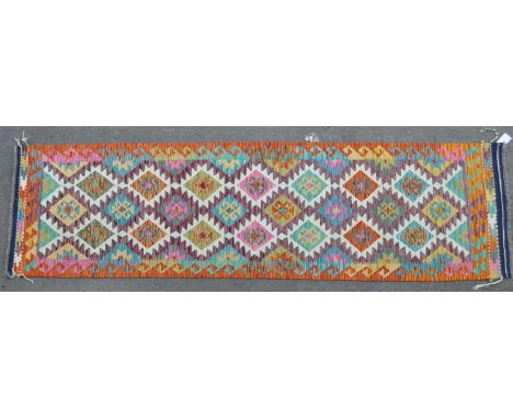 A 20th century Anatolian Turkish Kilim carpet runner rug. The rug featuring a central field with polychrome geometric pattern