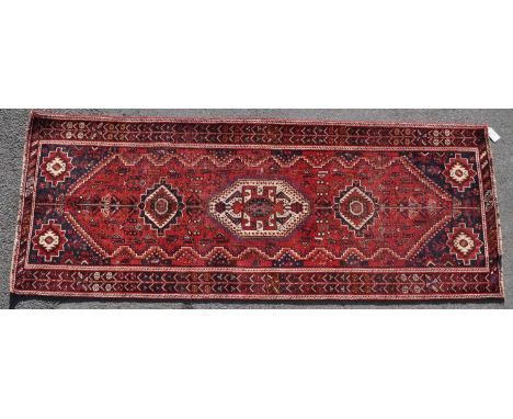 A 20th century South West Persian Islamic Qashgai floor carpet runner rug. The runner having a central panel with repeating g