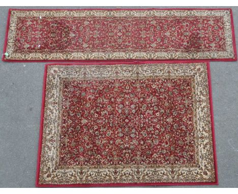 Two contemporary oriental Chinese style carpet floor rugs. Red ground with repeating floral design with white border. Togethe
