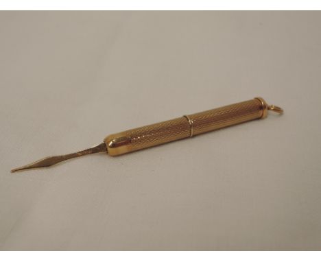 A 9ct gold retractable tooth pick having engine turned decoration