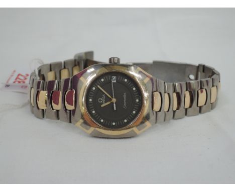 A gents 1980's Omega Seamaster Titanium and yellow metal quartz wrist watch having a dot dial with date aperture to grey/brow