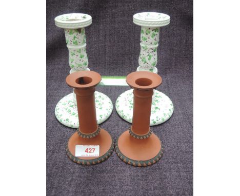 A pair of 19th century ceramic candlesticks having naturalistic decoration and a pair of 19th century terracotta Wedgwood can