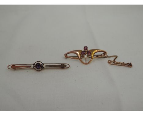 An Edwardian style yellow metal bar brooch stamped 9C having amethyst and seed pearl decoration, in original case and another
