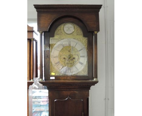 A late 18th century dark oak longcase clock having square and reeded pillar hood containing arch, brass and silvered face, 8 