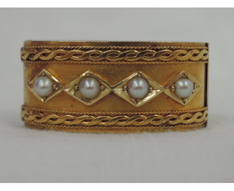 A yellow metal scarf ring having seed pearl and moulded decoration, no marks but tested as 15ct gold
