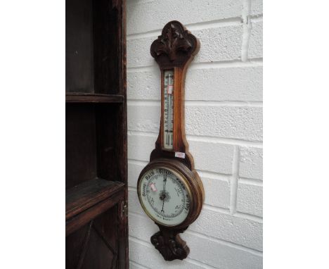 An early 20th century carved oak aneroid banjo barometer with thermometer scale