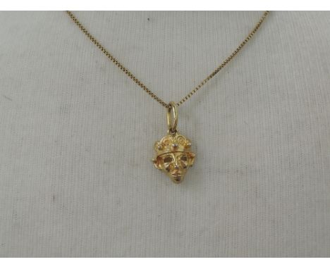 A yellow metal pendant modelled as a Peruvian Mayan mask on a yellow metal box chain stamped 585    approx 6.5g