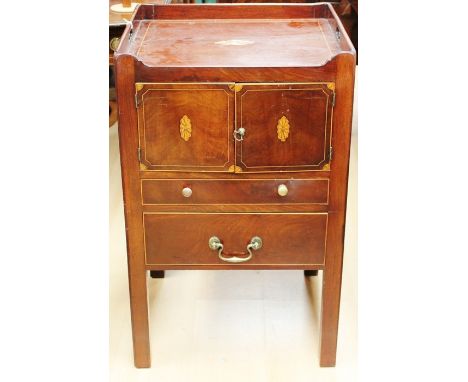 A George III mahogany night commode, circa 1775, the top inlaid with a shell panel of inlay, the front with two inlaid doors,