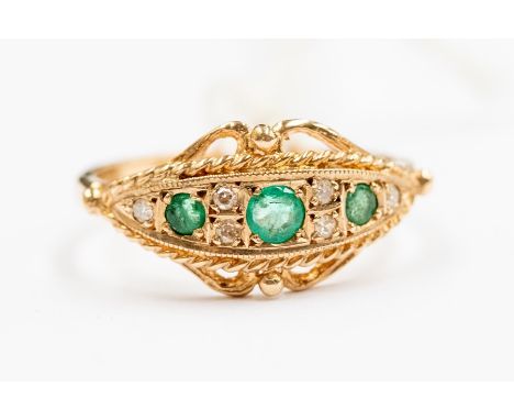 A Victorian style emerald and diamond 9ct gold ring, Etruscan design set with three round emeralds with diamond set accents, 