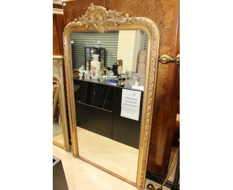 A large late 19th Century giltwood wall mirror, gesso moulded decoration to frame, scroll and shell moulded finial, beaded de