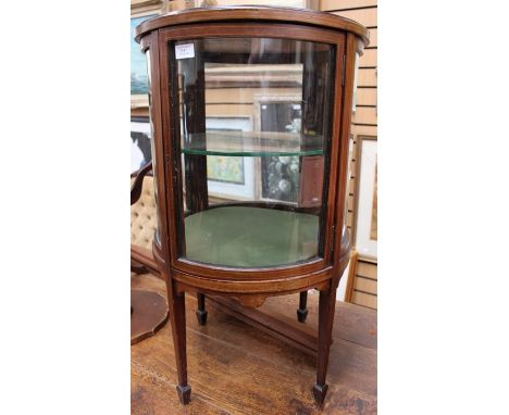 An Edwardian mahogany vitrine, curved form and fitted with a single door, shaped glass, 81cm high, 49cm diameterC R: Height 8