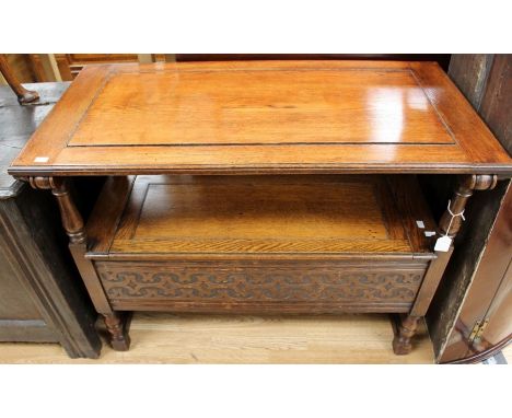 A mid 20th Century oak Monks bench, in the Jacobean style, having a lidded seat revealing storage section below