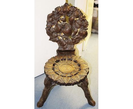 A late 19th Century Black Forest carved oak hall chair, elaborately carved throughout to back, the seat carved with a roundel