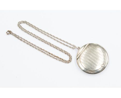 A silver compact pendant with mirror to interior, engine turned decoration, approx. 48mm, Birmingham 1945, on a fine white me