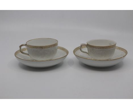 A pair of Berlin porcelain coffee cups and saucers, circa 1890, of rounded form and finely moulded with bianco-sopra-bianco s