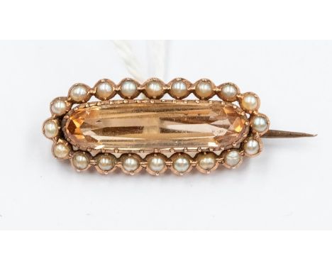 An Edwardian imperial topaz and seed pearl brooch, the lozenge topaz approx. 19mm x 5mm, claw set within a border of seed pea