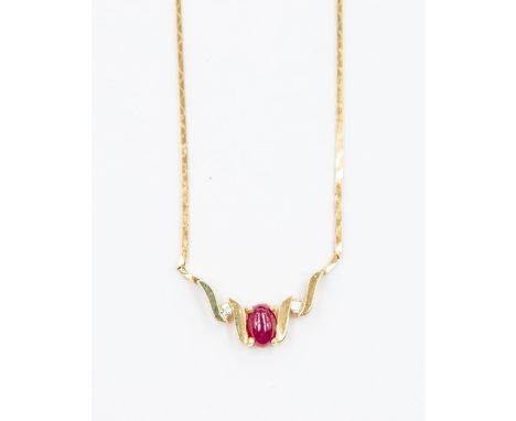 A ruby and diamond 14k gold neck-let set with an oval cabochon ruby, approx. 5 x 3mm, two claw set brilliant cut diamonds, to