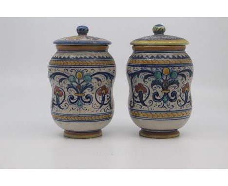 A pair of small Deruta maiolica albarello and covers, circa 1930, of typically waisted form and decorated with polychrome scr