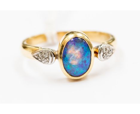 An opal and diamond dress ring, the oval opal approx 9 mm x 6 mm, with blue green play of colour, small grain set diamonds ei