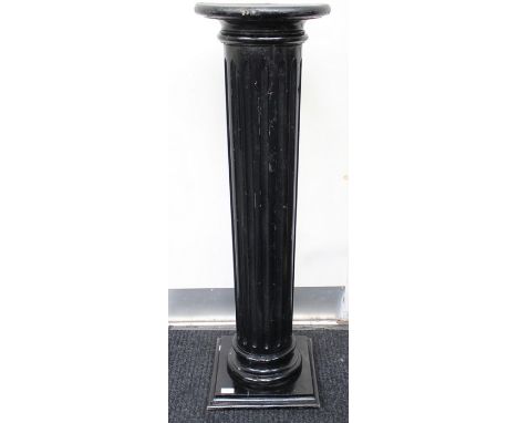 A 20th Century ebonised classical style single column torchere, the column turned and carved with vertical fluting from a sin