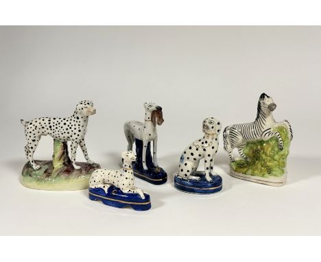 A group of five Staffordshire models, 19th century and later, comprising: a flatback prancing zebra; a large standing dalmati