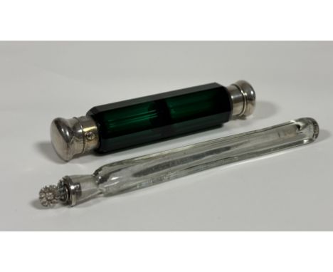 Two late 19th century scent bottles: the first a double-ended bottle in green glass, of faceted form, the white metal caps un