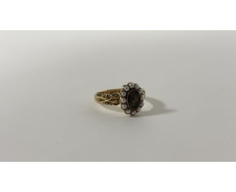 An Edwardian 18ct gold mourning ring, the central glazed hair locket within a band of seed pearls on scroll-cast shoulders, h