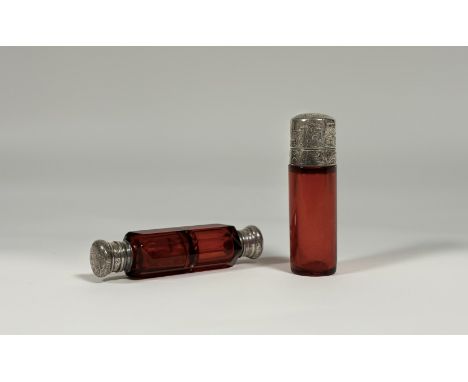 Two late 19th century ruby glass scent bottles: the first double-ended in faceted glass with engraved white metal tops (unmar