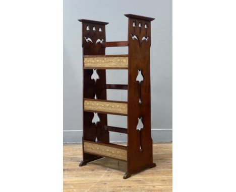 An Arts and Crafts period cherry three tier book stand, each sloping shelf having an applied embroidered textile panel, and r