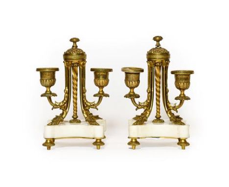 A Pair of French Gilt Metal and White Marble Twin-Light Candelabra, circa 1870, with fluted campana sockets and leaf sheathed