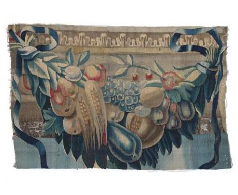 A 17th Century Flemish Border Tapestry Fragment, worked in silk and wool depicting a swag of exotic fruit flanked by scrollin