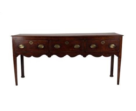 A George II Oak and Mahogany Crossbanded Low Dresser, mid 18th century, the moulded top above three deep drawers and wavy sha
