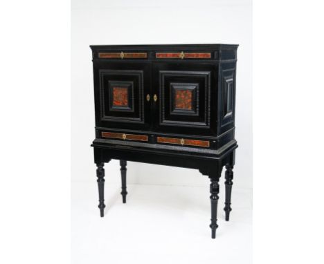 A 19th century Antwerp style ebony and tortoiseshell veneered and ebonised cabinet on stand, the plain top over two drawer fr