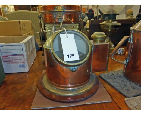 A antique copper cased ships binnacle compass, with circular glass viewing panel and lamp box to the side.