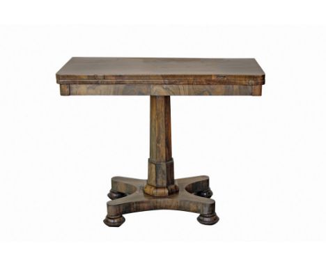 A George IV rosewood fold-over card table, the foldover top on a tapered octagonal column and incuse quatreform base, with la