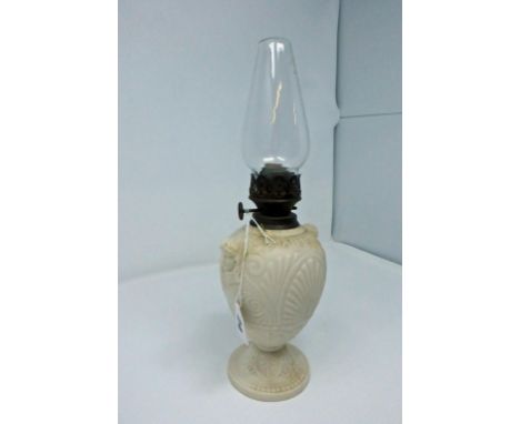 A Parian / biscuit porcelain oil lamp by Copeland, foliate design throughout, with mask to either side, overall height 12½in.