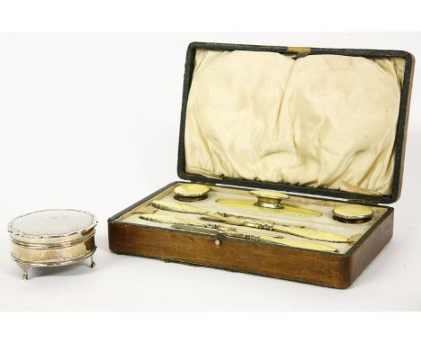 A cased silver, enamel and engine turned manicure set, and a silver dressing table boxProvenance:  The Estate of the late Mrs
