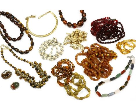 A collection of bead necklaces, including a silver banded agate brooch, a three row red glass faceted bead necklace with silv