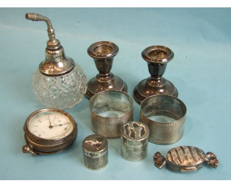 A pair of silver engine-turned napkin rings inscribed with name, Birmingham 1943, a pair of small loaded silver candlesticks,