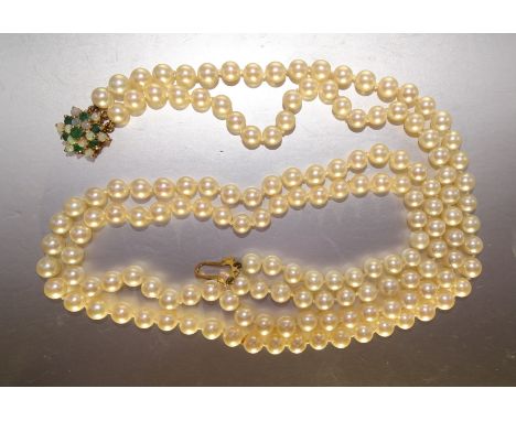 A cultured pearl necklace of two strings of uniform cultured pearls, to a 9ct gold clasp set opal and emerald cluster, 153 pe