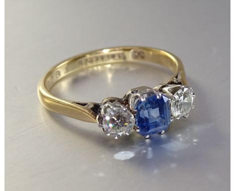 A sapphire and diamond ring, claw-set a step-cut sapphire between two brilliant-cut diamonds, total diamond weight approximat