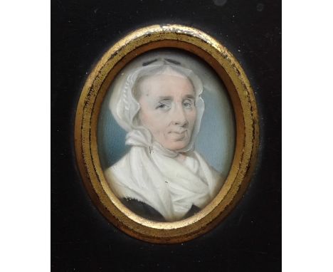 An early 19th century oval portrait miniature of a mature lady wearing a white cap and fichu, 38 x 30mm, in oblong frame 11.5