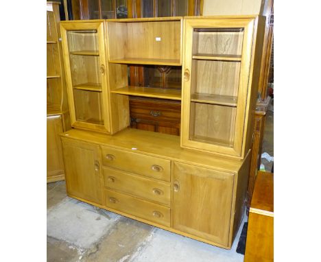 An Ercol Windsor-style elm sideboard/display cabinet, having a twin glazed door bookcase top with central shelf section, abov