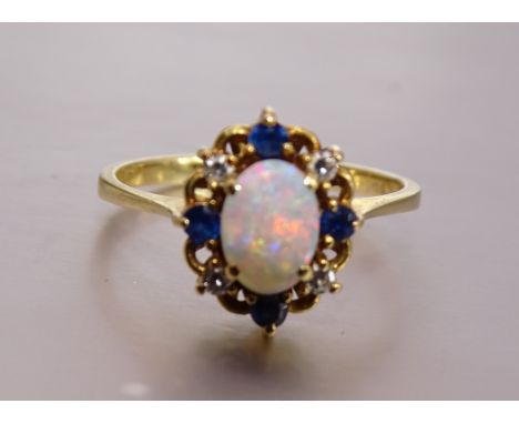 An opal, sapphire and diamond cluster ring, the oval opal within a surround of four each round-cut sapphires and 8/8-cut diam