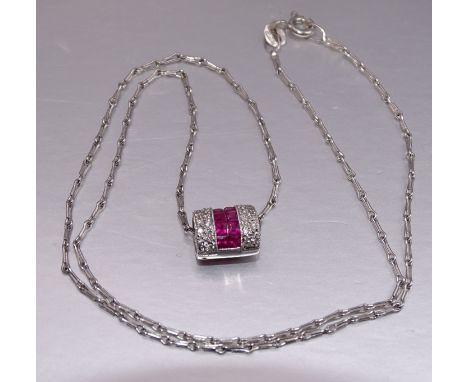 A ruby and diamond pendant of oval cylinder form, channel-set ten square cut rubies between pavé-set diamond panels, in 18ct 