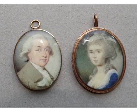 A Georgian yellow metal oval locket containing a portrait miniature of a young woman wearing a lace trimmed blue dress 38 x 3