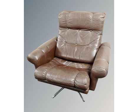 A Scandinavian brown button leather armchair on chrome swivel base 
