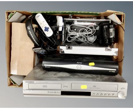A box containing assorted electricals including Samsung DVD/VCR recorder, Sky+ HD box, hair grooming kit, field glasses, Senn