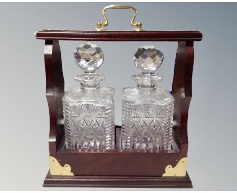 A two bottle Tantalus with key containing two lead crystal whisky decanters.