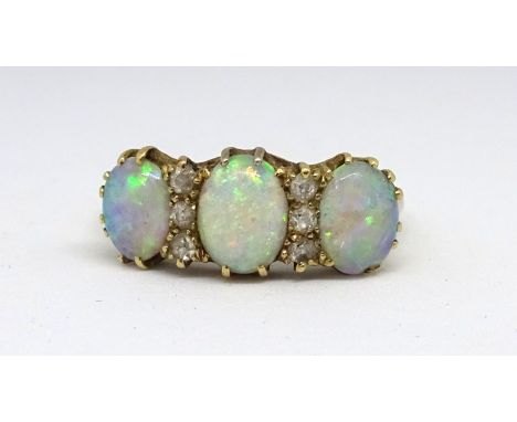 A 18ct opal six stone ring set within round small cut diamonds, size O.